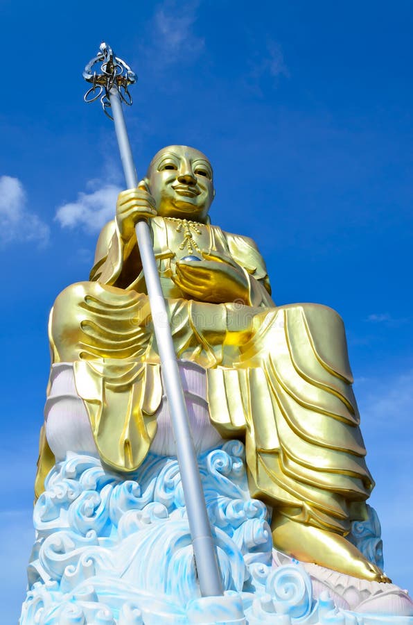 Grande statua dorata di bodhisattva con cielo blu immagine stock Grande statua dorata di bodhisattva con cielo blu immagine stock