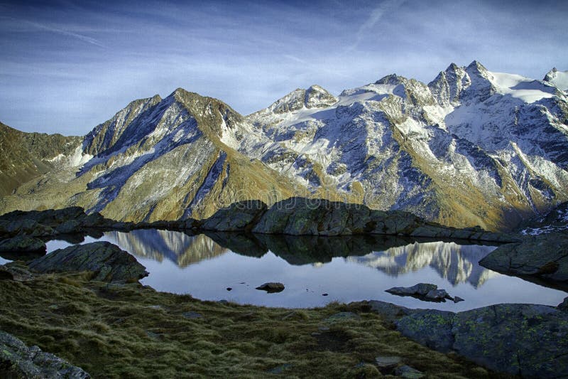 Grande vista do lago pequeno no parque nacional de Gran Paradiso, cumes, Itália, mundo bonito cenário calmo com as montanhas cobe imagens de stock Grande vista do lago pequeno no parque nacional de Gran Paradiso, cumes, Itália, mundo bonito cenário calmo com as montanhas cobe imagens de stock