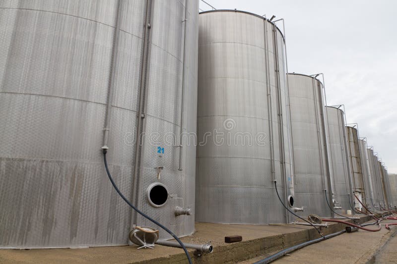 Rows of large steel tank vessels on a factory yard for storing liquids industrial style. Rows of large steel tank vessels on a factory yard for storing liquids industrial style