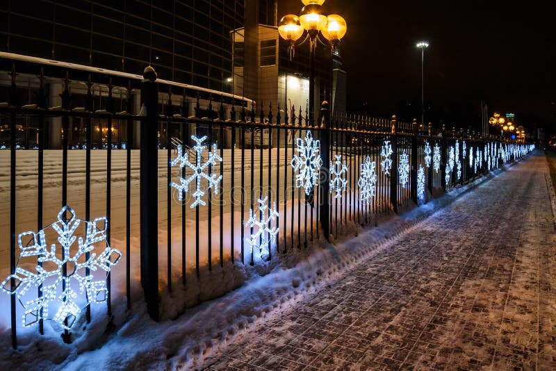 Un Grand Arbre De Noël Avec Les Guirlandes Lumineuses Et L'étoile Brillent  Le Duvet Léger Sur La Rue En Hiver Décoration De La Vi Photographie  éditorial - Image du cadre, vert: 99101552