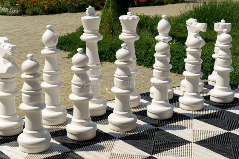 Peças grandes e tabuleiro de xadrez gigante de xadrez de rua no parque foco  seletivo