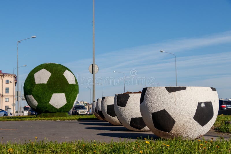 Grandes vasos na forma de uma bola para o futebol A bola de futebol verde gigante é a decoração da cidade para o campeonato do mu fotos de stock Grandes vasos na forma de uma bola para o futebol A bola de futebol verde gigante é a decoração da cidade para o campeonato do mu fotos de stock