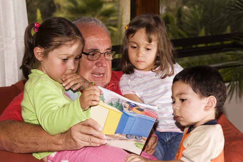 Grandfather and grandchildren reading together royalty free stock photos Grandfather and grandchildren reading together royalty free stock photos