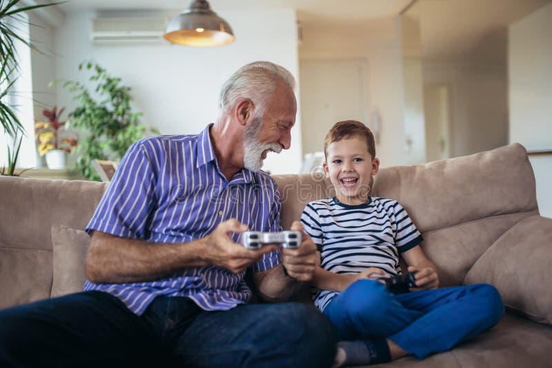 Grandfather and grandson are playing video games. 