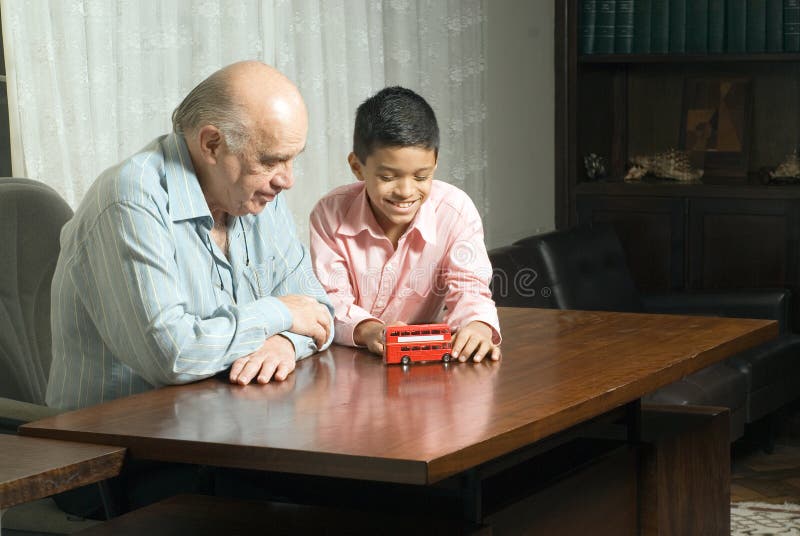 Grandfather and grandson sitting at the table with