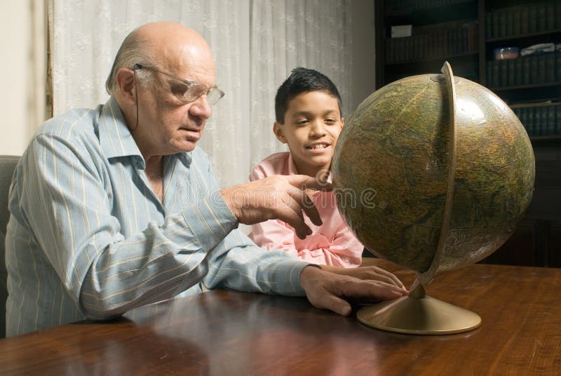 Grandfather and grandson sitting at table with glo