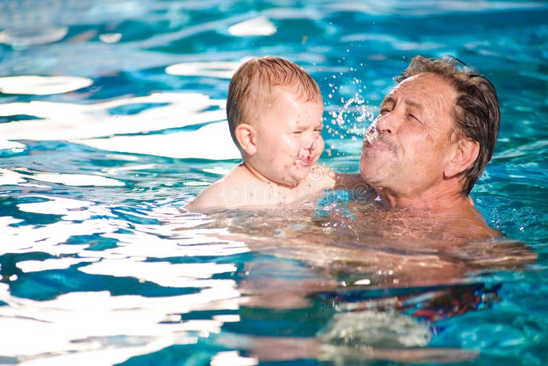 Nonno e nipote a giocare insieme in piscina.