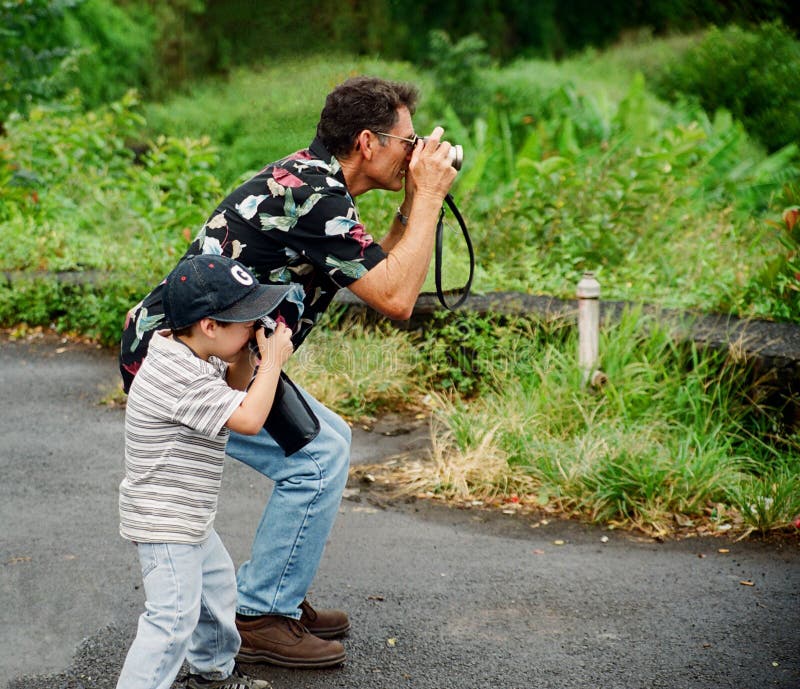 Nieto proceso de copiar abuelo fotografías mientras sobre el día festivo en.