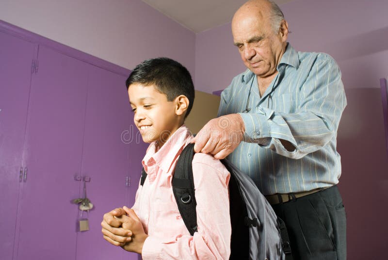 Grandfather helping grandson get ready to leave -