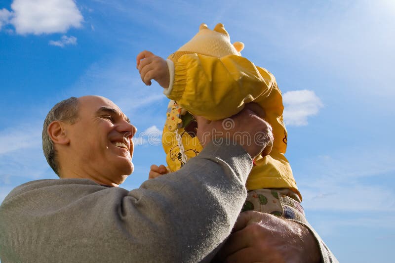 Grandfather holds his granddaughter in hands