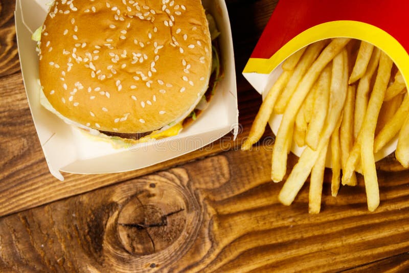 Grandi hamburger e patate fritte sulla tavola di legno fotografia stock libera da diritti Grandi hamburger e patate fritte sulla tavola di legno fotografia stock libera da diritti
