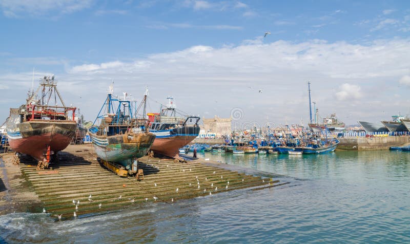 Grandi pescherecci di legno ancorati sul bacino di carenaggio in porto della città medievale Essaouira, Marocco, Nord Africa fotografia stock Grandi pescherecci di legno ancorati sul bacino di carenaggio in porto della città medievale Essaouira, Marocco, Nord Africa fotografia stock