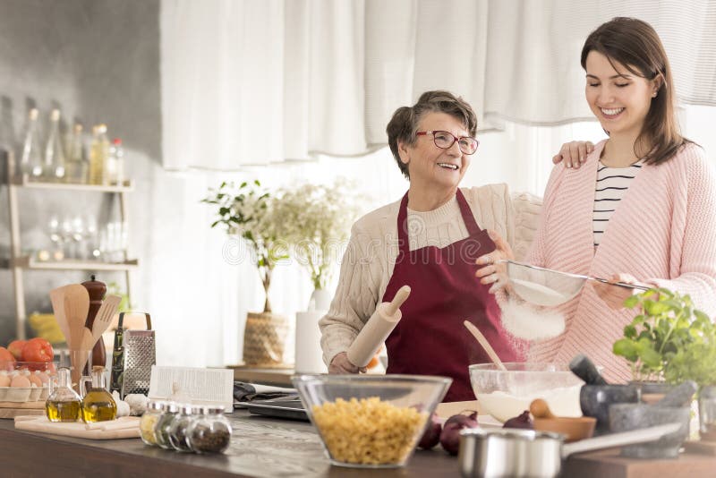 Grandma and granddaughter baking a cake stock image