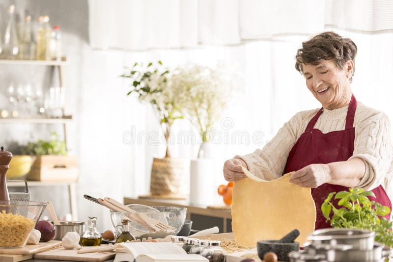 Grandma making a dough stock photos