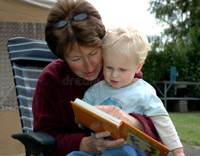 Grandma reading a book for her grandchild, both enjoying and having a good (learning) time. Old granny stock images, royalty-free photos and pictures