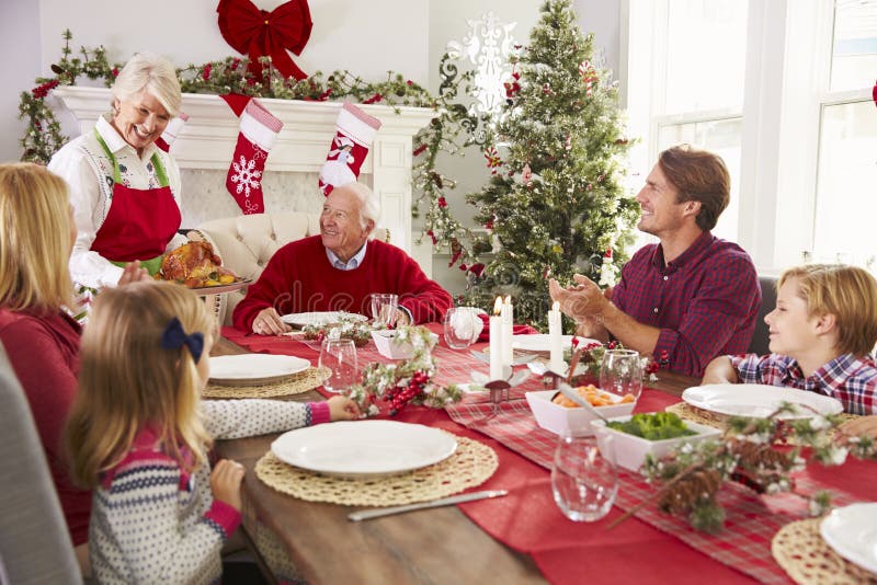 Grandmother Bringing Out Turkey At Family Christmas Meal.