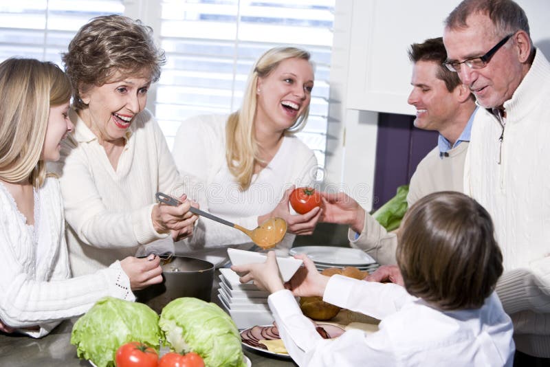 Grandmother with family laughing in kitchen royalty free stock image