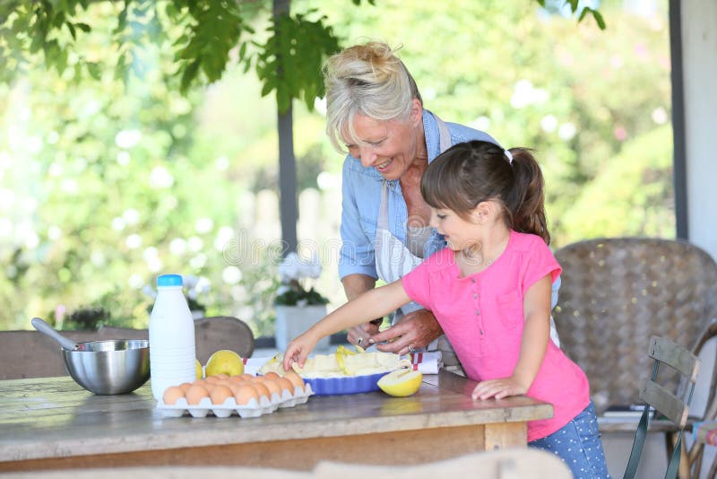 Grandmother and granddaughter making an apple pie royalty free stock photo Grandmother and granddaughter making an apple pie royalty free stock photo