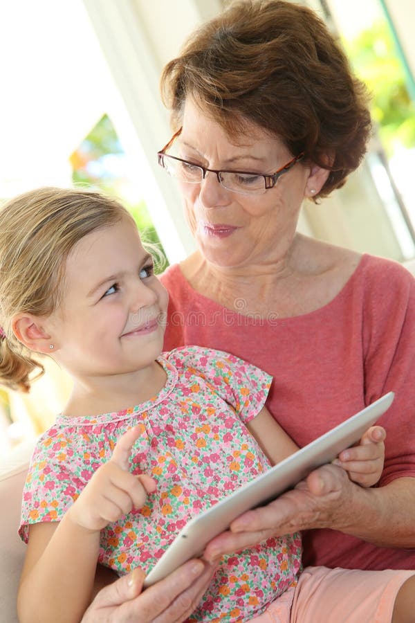 Grandmother and granddaughter playing on a tablet