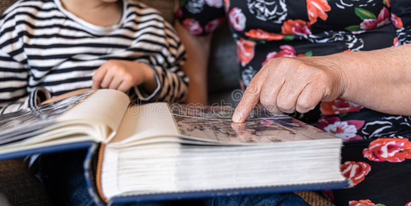 A grandmother with her granddaughter looking at a family photo album
