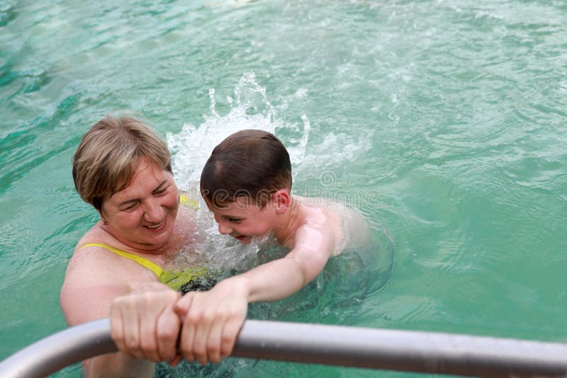 Grandmother with her grandson in jacuzzi of pool stock image
