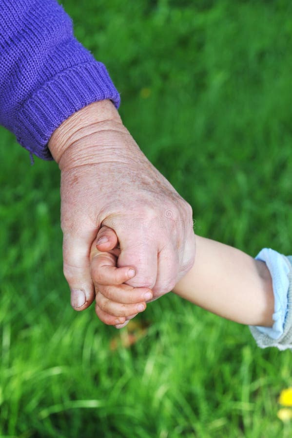 Grandmother holds child hand