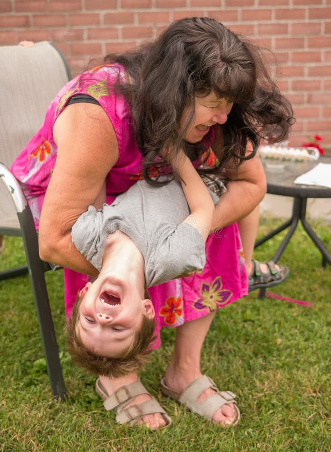 La nonna a giocare con suo nipote, entrambi a ridere e assaporando il momento di esuberanza giovanile.