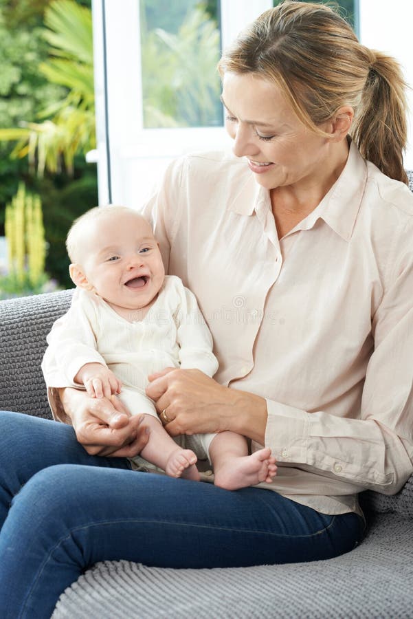 Grandmother Sitting On Sofa With Baby Granddaughter royalty free stock images Grandmother Sitting On Sofa With Baby Granddaughter royalty free stock images