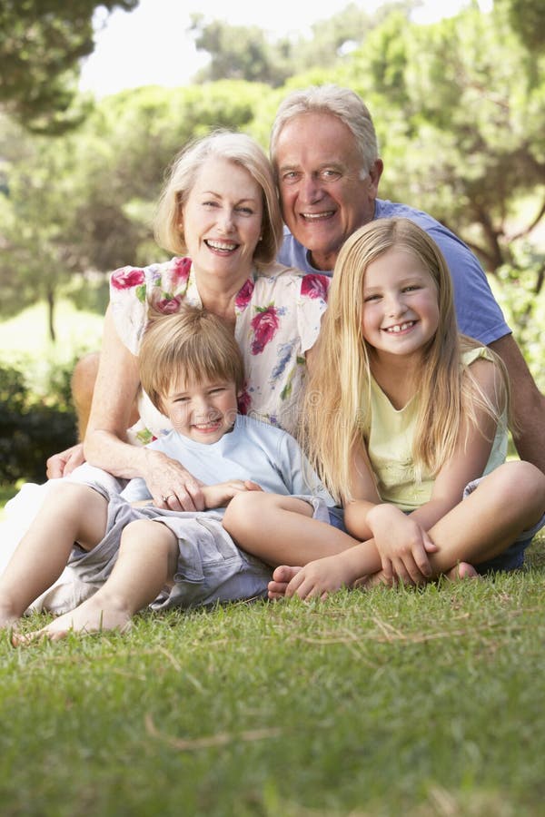 Grandparents And Grandchildren Sitting In Park Together stock photography Grandparents And Grandchildren Sitting In Park Together stock photography