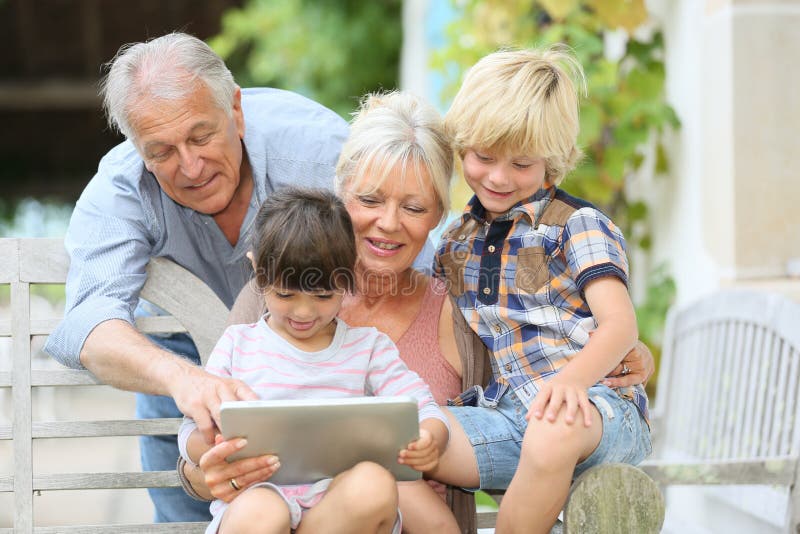 Grandparents and grandchildren using tablet