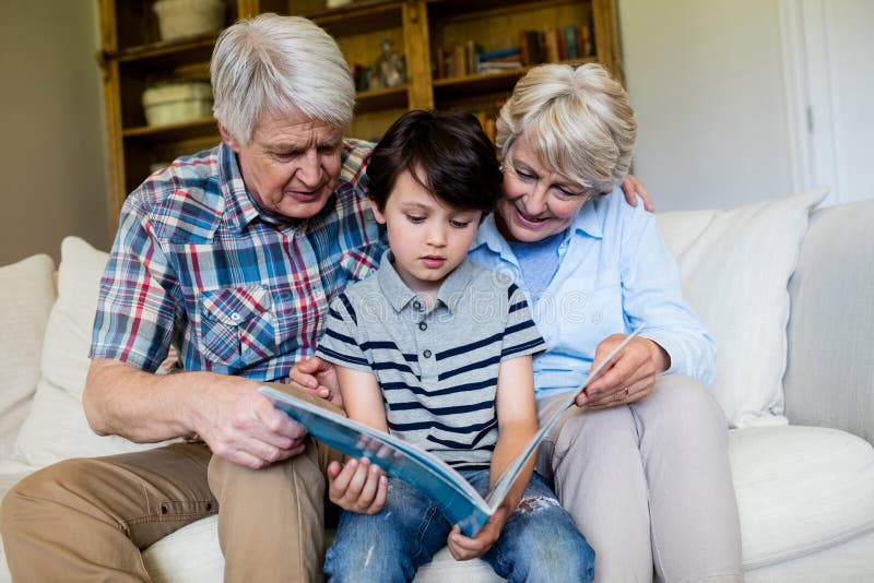 Grandpa is in the bedroom. Внук дома. Grandparents looked after their grandson. Grandparents in the livingroom. Дедушка и внучка вместе читают книгу на диване.