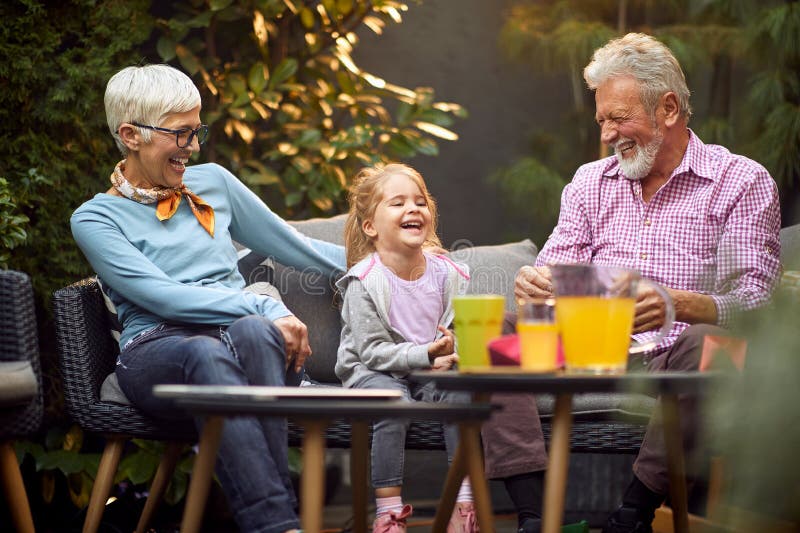 Grandparents laughing out loud with their granddaughter, having wonderful time