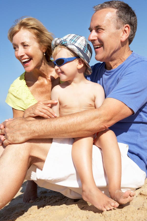 Grandparents и внук сидя на пляже стоковое изображение Grandparents и внук сидя на пляже стоковое изображение