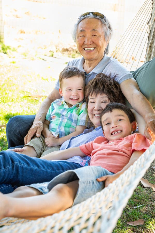 Grands-parents chinois dans l'hamac avec des enfants de métis photos libres de droits Grands-parents chinois dans l'hamac avec des enfants de métis photos libres de droits