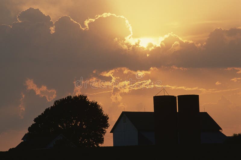 Grange avec le silo au coucher du soleil images stock Grange avec le silo au coucher du soleil images stock