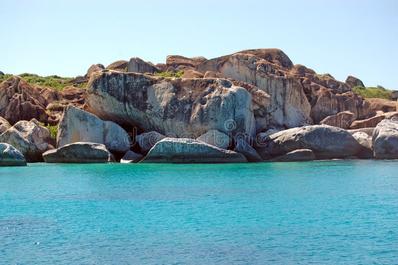 Granite rock face and turquoise waters stock images