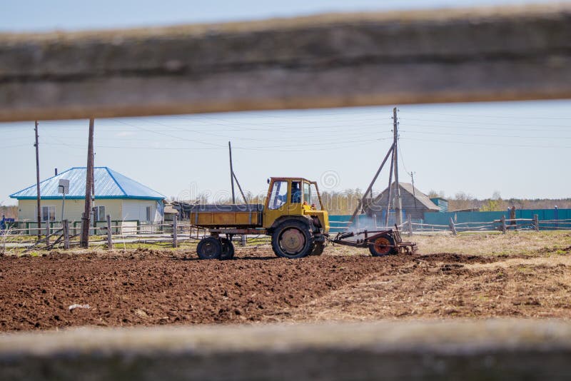 Granjero en el tractor que prepara la tierra con el cultivador del semillero fotografía de archivo libre de regalías Granjero en el tractor que prepara la tierra con el cultivador del semillero fotografía de archivo libre de regalías