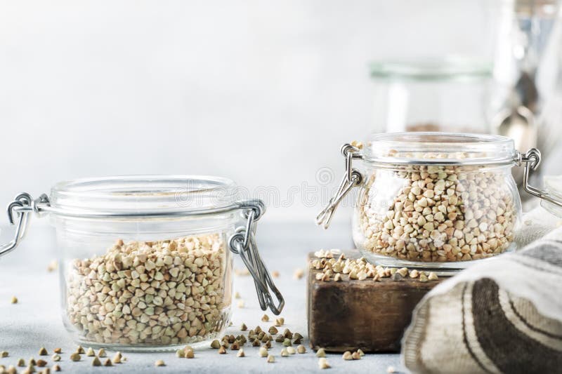 Grano saraceno verde in barattolo di vetro, in alimento vegetariano sano o nel concetto crudo degli alimenti, fondo grigio del ta fotografie stock libere da diritti Grano saraceno verde in barattolo di vetro, in alimento vegetariano sano o nel concetto crudo degli alimenti, fondo grigio del ta fotografie stock libere da diritti