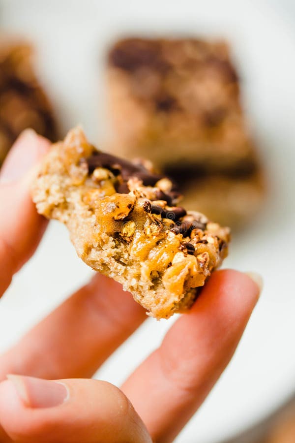 Granola bar-cake with chocolate, a stack of sliced pieces in a white bowl. Dietic dessert. Healthy vegan food concept. The process stock image Granola bar-cake with chocolate, a stack of sliced pieces in a white bowl. Dietic dessert. Healthy vegan food concept. The process stock image