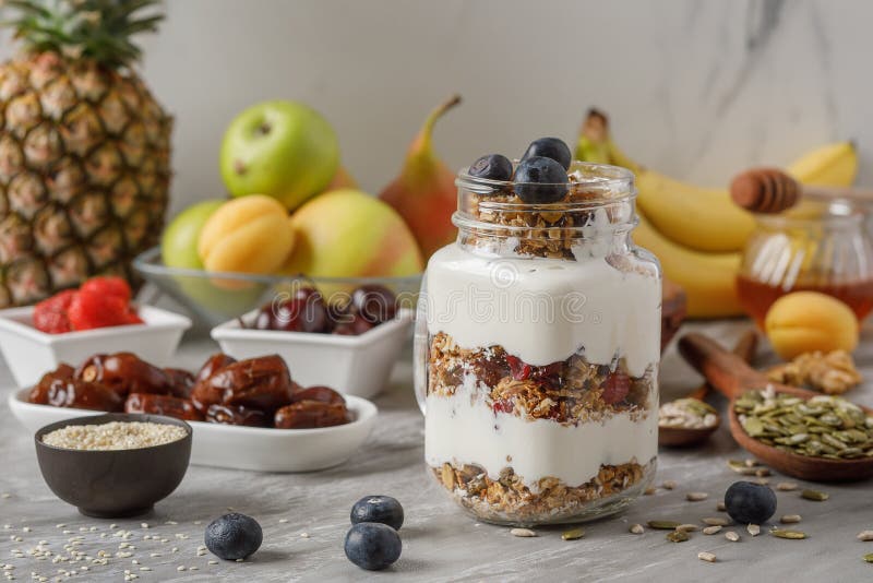 Granola et yaourt et fruits sur compléter en verre sur la table en pierre, nourriture saine pour le concept de régime photographie stock libre de droits Granola et yaourt et fruits sur compléter en verre sur la table en pierre, nourriture saine pour le concept de régime photographie stock libre de droits
