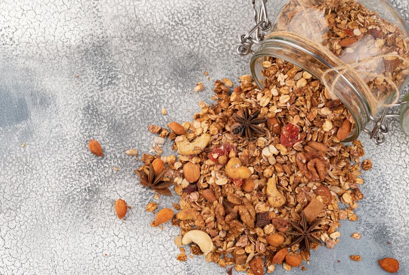 Granola hecho en casa en tarro de cristal abierto en fondo ligero fotografía de archivo Granola hecho en casa en tarro de cristal abierto en fondo ligero fotografía de archivo
