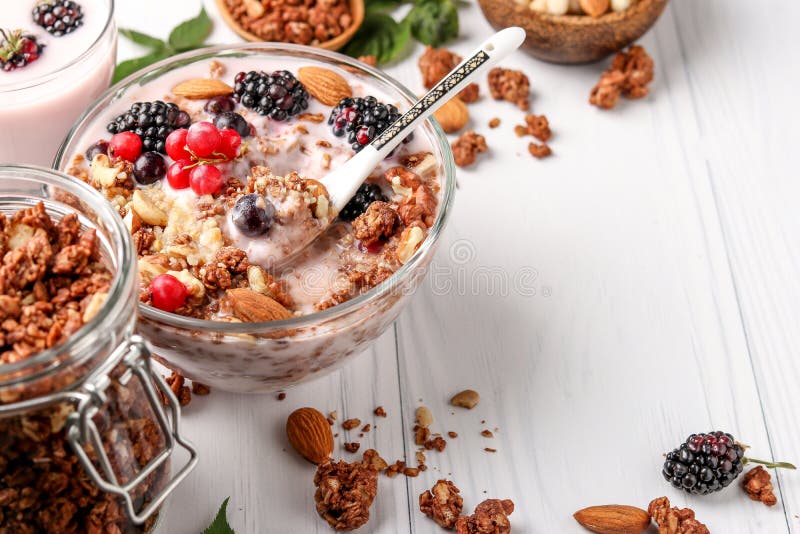 Granola-Müsli aus knusprigem Honig mit natürlichem Jogurt, frischen Beeren, Schokolade und Nüssen in einer Glasschüssel mit he stockfotos Granola-Müsli aus knusprigem Honig mit natürlichem Jogurt, frischen Beeren, Schokolade und Nüssen in einer Glasschüssel mit he stockfotos