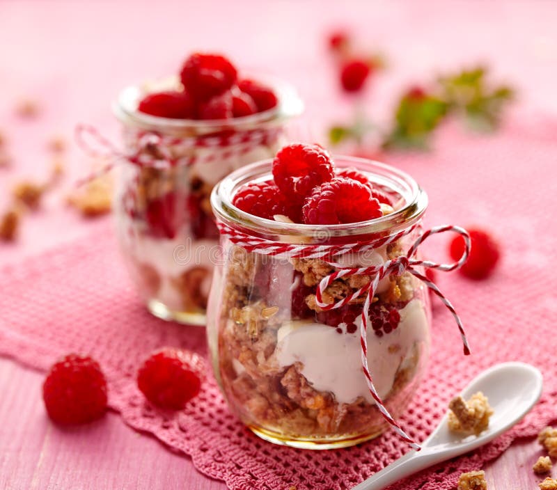 Granola με τα φρέσκα σμέουρα και φυσικό γιαούρτι σε ένα βάζο γυαλιού σε έναν ξύλινο ρόδινο πίνακα Εύγευστο πρόγευμα ή επιδόρπιο στοκ φωτογραφία Granola με τα φρέσκα σμέουρα και φυσικό γιαούρτι σε ένα βάζο γυαλιού σε έναν ξύλινο ρόδινο πίνακα Εύγευστο πρόγευμα ή επιδόρπιο στοκ φωτογραφία