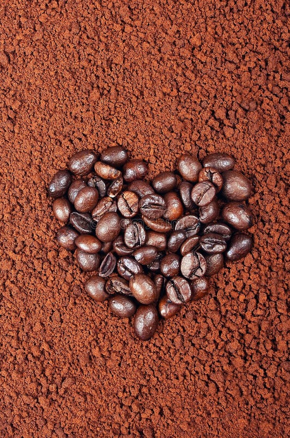 GRANOS DE CAFÉ EN FORMA DE CORAZÓN EN FONDO DEL CAFÉ INSTANTÁNEO imagenes de archivo GRANOS DE CAFÉ EN FORMA DE CORAZÓN EN FONDO DEL CAFÉ INSTANTÁNEO imagenes de archivo