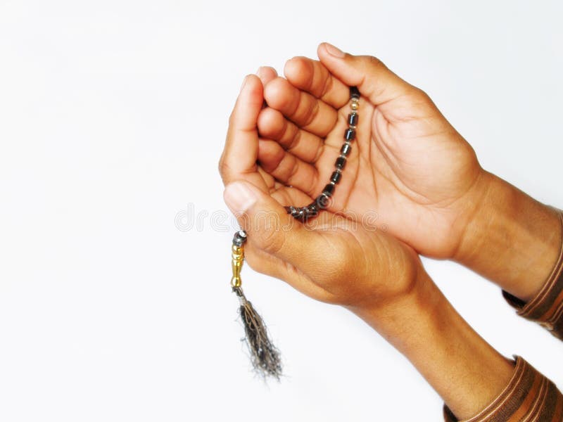 A view of two hands holding a set of Muslim prayer beads on a white background. Prayer beads sometimes called misbaha or subha. A view of two hands holding a set of Muslim prayer beads on a white background. Prayer beads sometimes called misbaha or subha.