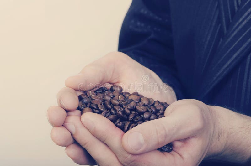 Granos del café sólo en las manos masculinas imagenes de archivo Granos del café sólo en las manos masculinas imagenes de archivo