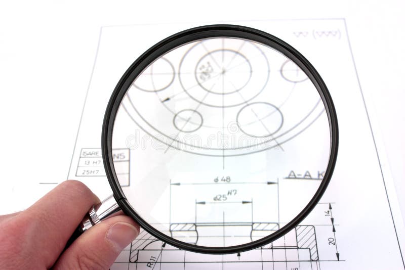 Reviewing technical drawing with magnifying glass. Focus on magnifying glass. Reviewing technical drawing with magnifying glass. Focus on magnifying glass.