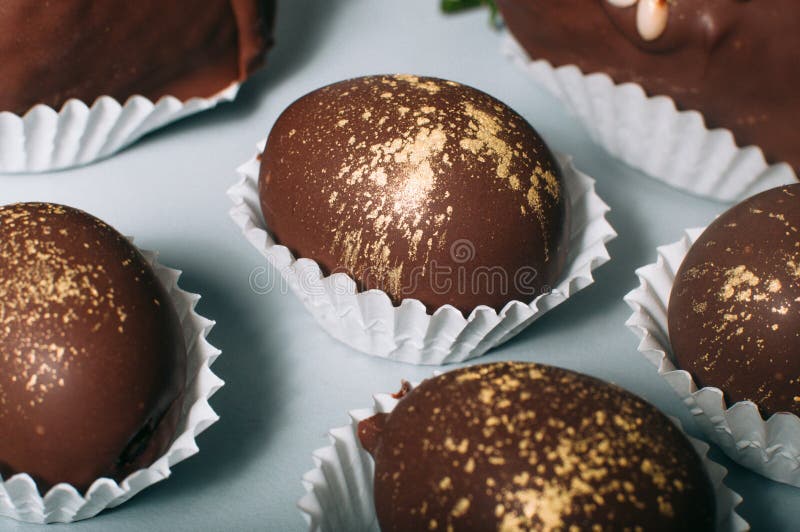 Close-up view of delicious grapes covered with milk chocolate decorated with edible gold