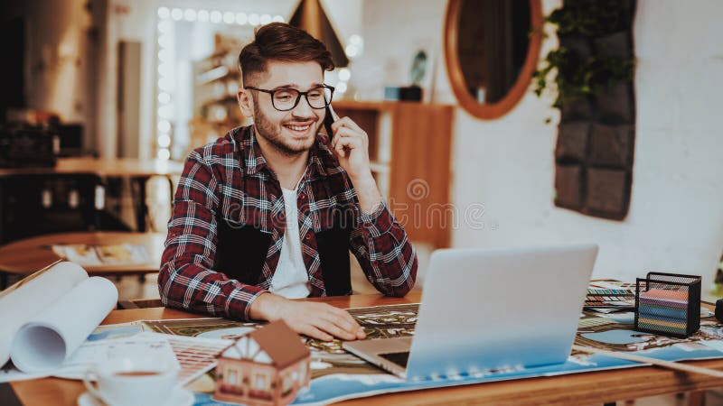 Graphic Designer Has Phone Call Working on Laptop