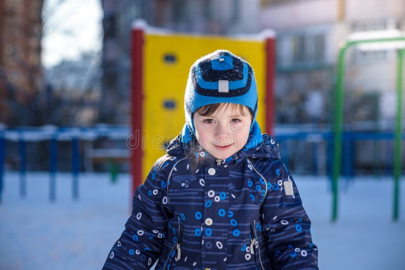 Grappig weinig jong geitjejongen die in kleurrijke kleren in openlucht tijdens sneeuwval spelen Actieve vrije tijd met kinderen i stock foto Grappig weinig jong geitjejongen die in kleurrijke kleren in openlucht tijdens sneeuwval spelen Actieve vrije tijd met kinderen i stock foto